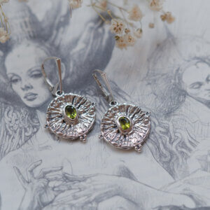 srebrne kolczyki z peridotem na tle ilustracji