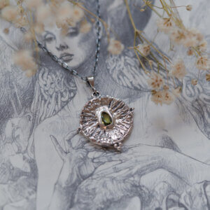 srebrny naszyjnik z peridotem na tle ilustracji