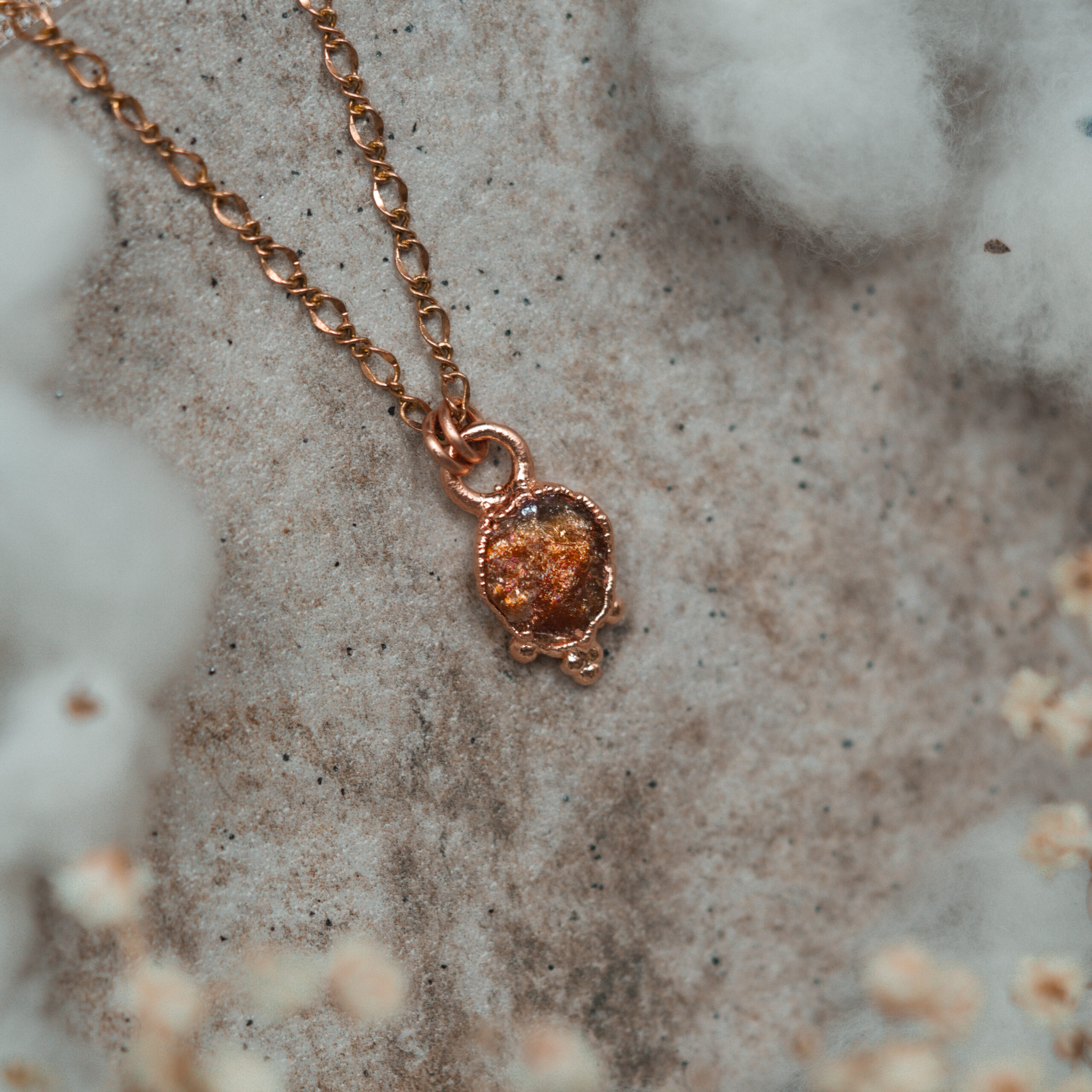 surowy kamień słoneczny w miedzianej oprawie