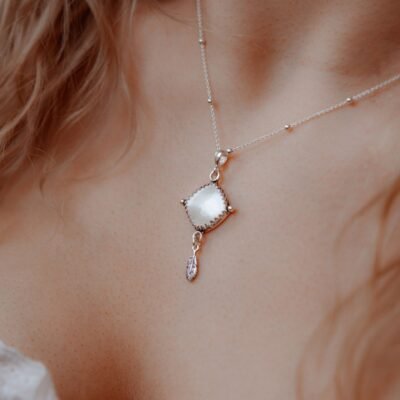 Srebrny naszyjnik z białą muszlą i piórkiem