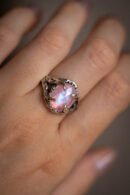 Ein silberner Ring mit einem rosa Mondstein an der Hand